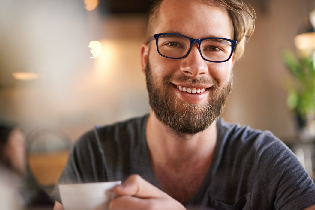 Man with glasses holding a hot mug